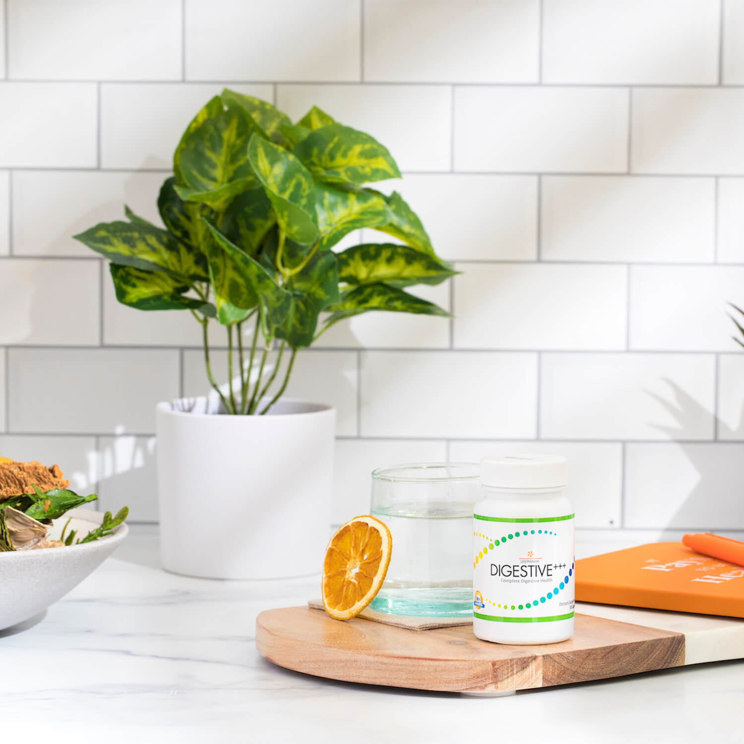 DIGESTIVE+++ on a kitchen countertop with sunlight, orange slice and water. Made for daily gut health and digestion support.